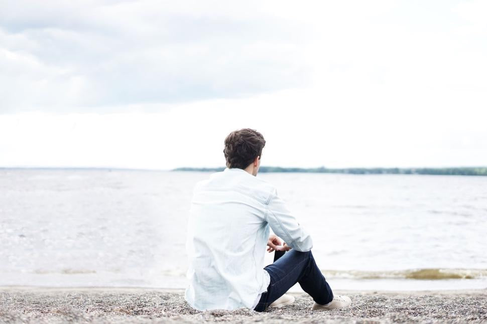 man sitting on beach, taking a mental break